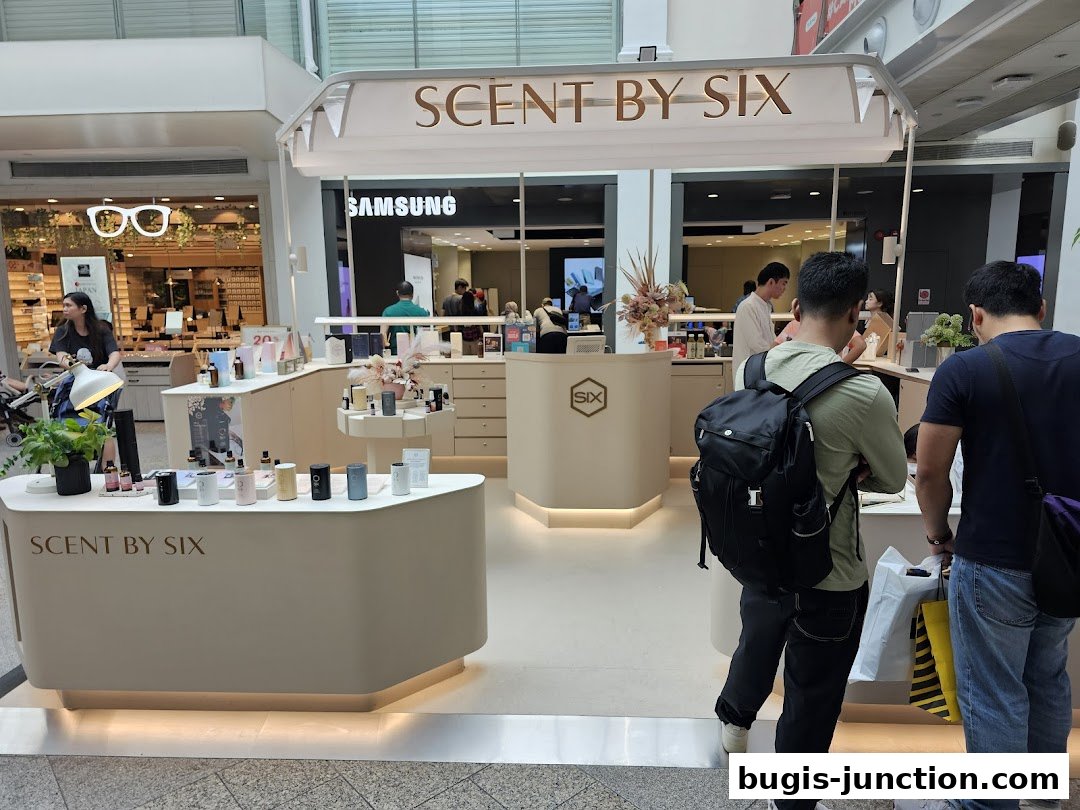 A Scent by SIX store counter displaying various fragrance products with customers browsing.
