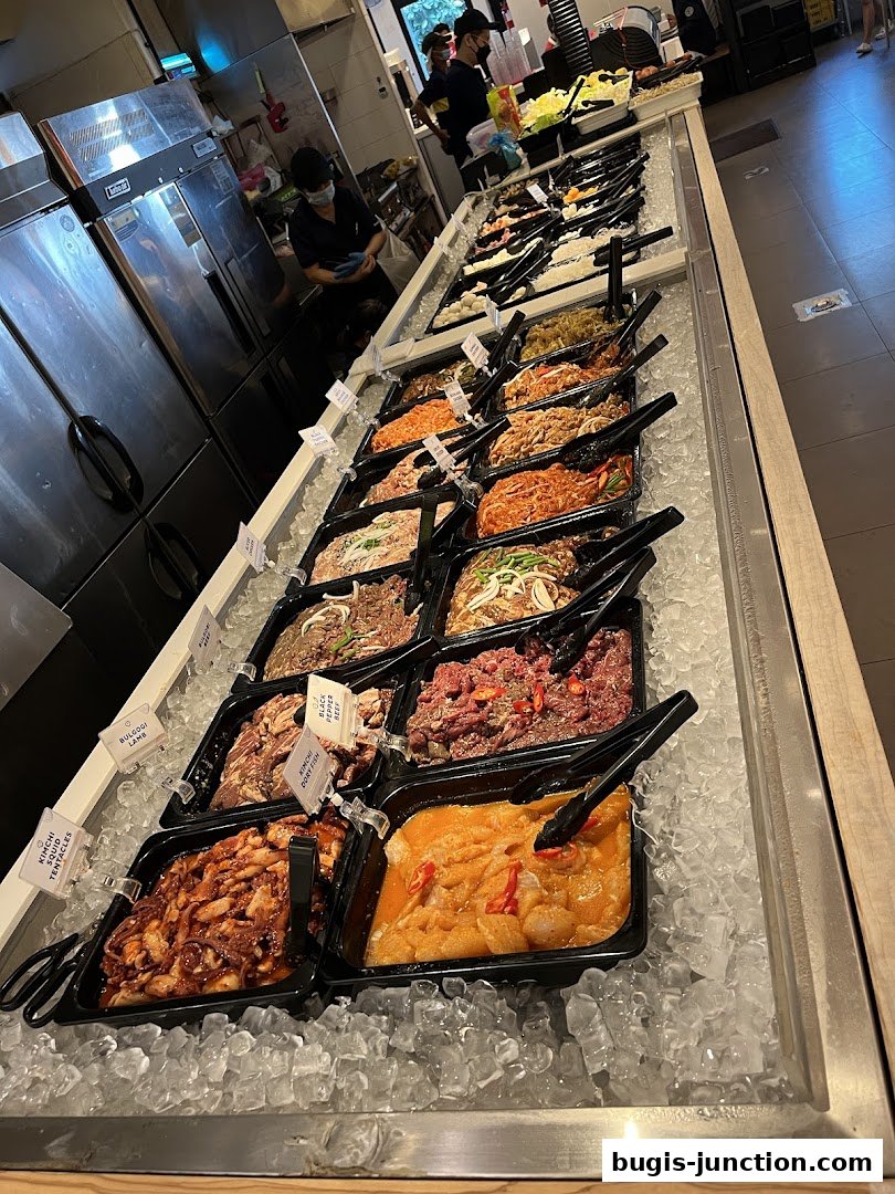 A display of various marinated meats and seafood on ice at a Korean BBQ restaurant.