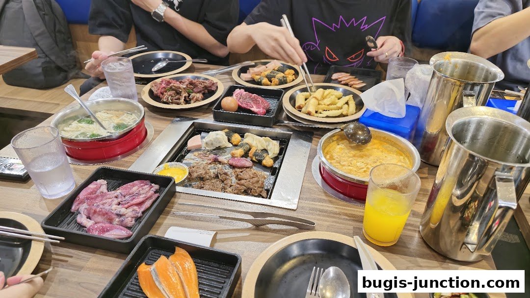 A table filled with various Korean BBQ dishes, including meats, seafood, and side dishes.