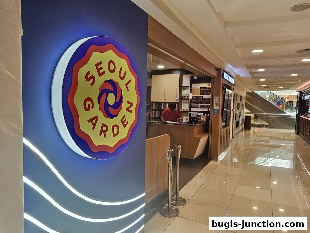 The entrance to Seoul Garden restaurant with its distinctive logo and a staff member at the counter.