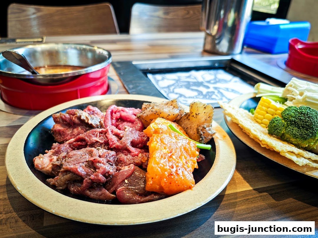 A close-up of a hot pot meal with raw meat, vegetables, and a dipping sauce.