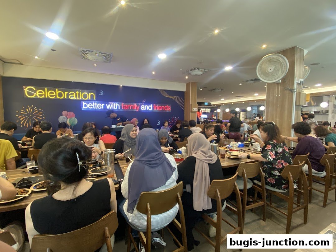 Diners enjoying a meal at Seoul Garden, with a neon sign saying 'Celebration better with family and friends'.