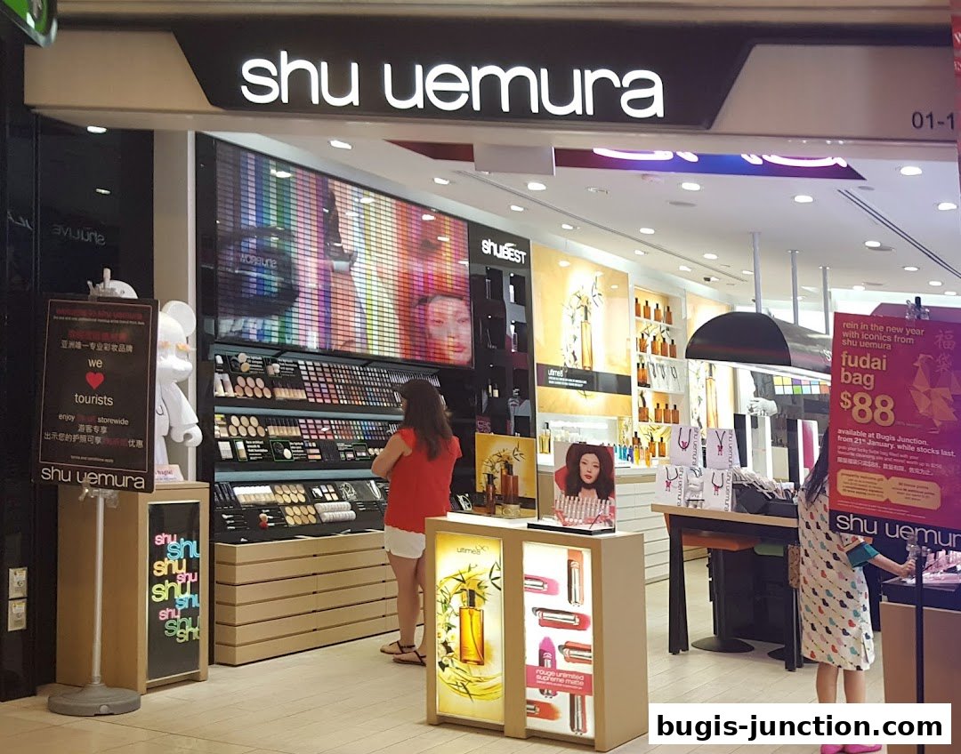 The Shu Uemura store at Bugis Junction showcases makeup displays and a promotional sign.