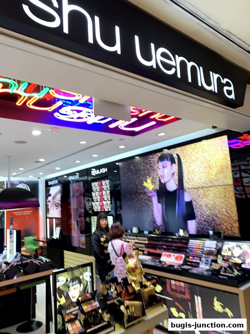 Shu Uemura makeup store interior with displays of cosmetics and promotional imagery.