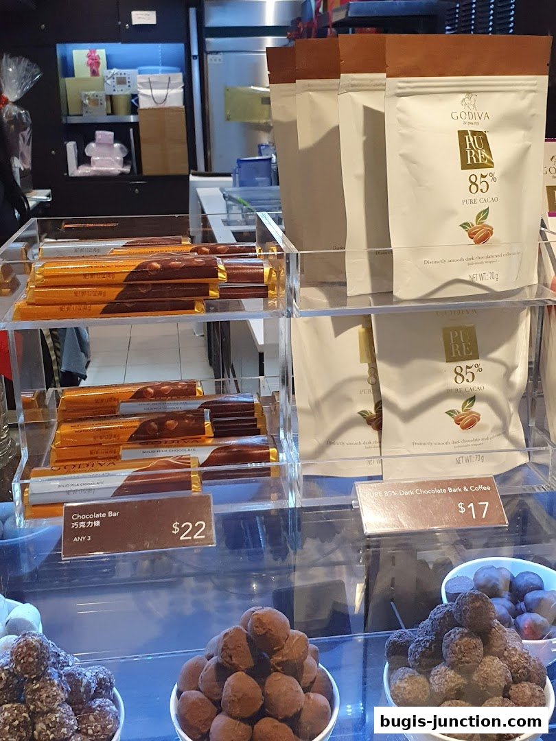 Godiva chocolates displayed in clear cases, featuring chocolate bars and truffle assortments.