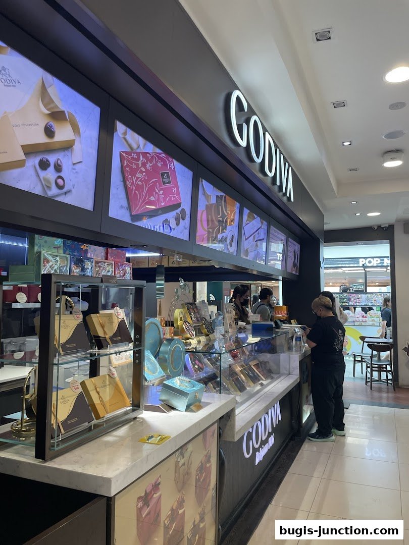 A Godiva chocolate shop counter displaying various chocolate boxes and gift sets.