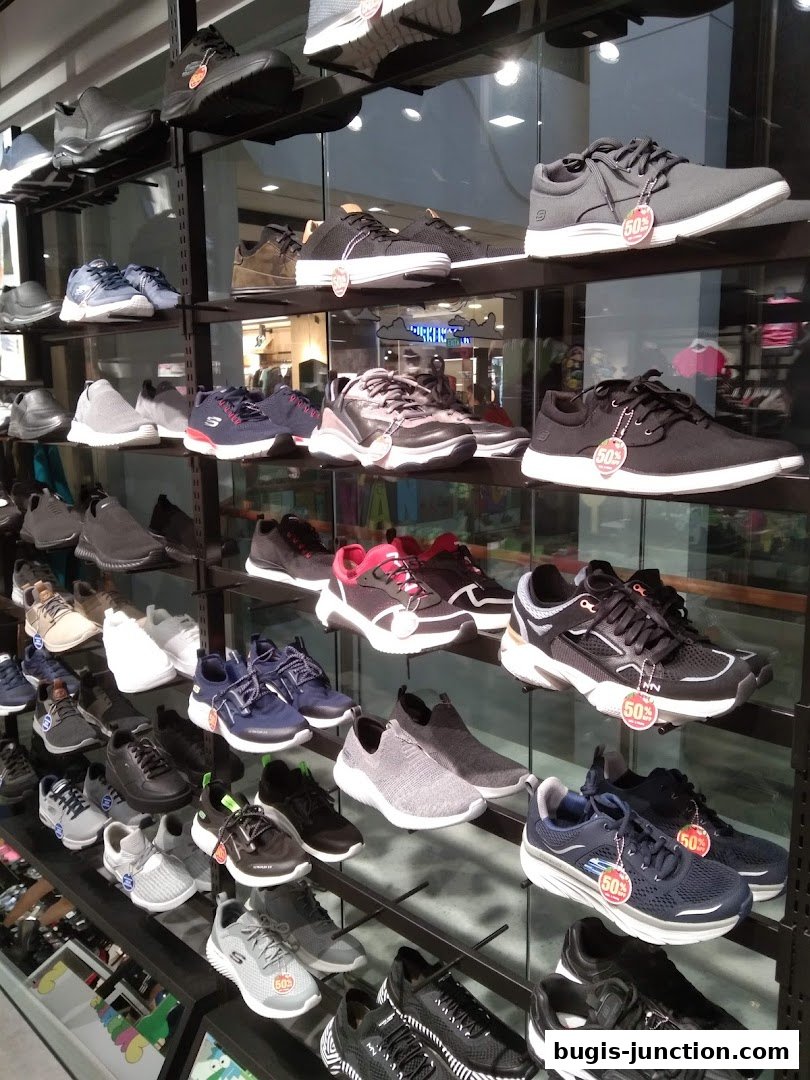 A wide selection of Skechers athletic shoes displayed on shelves in a retail store.