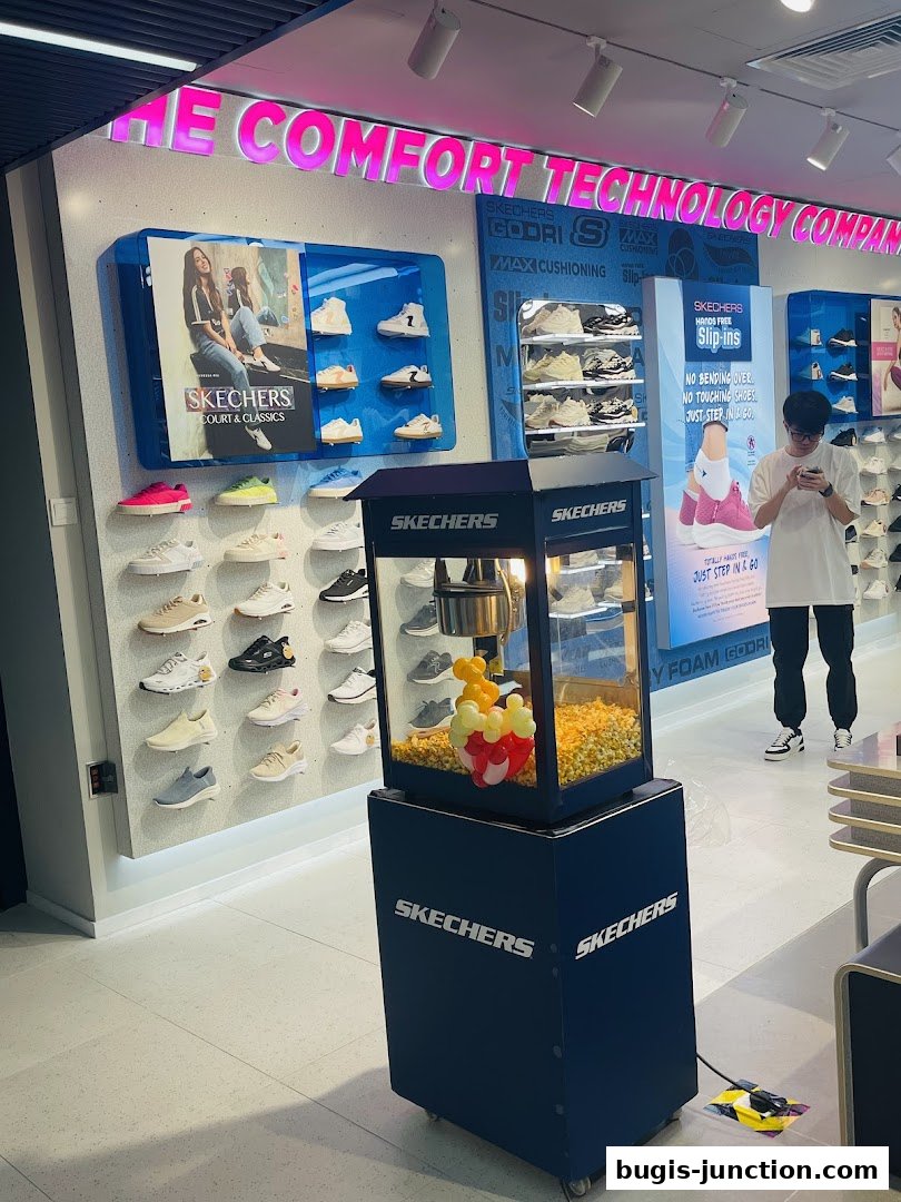 Interior of a Skechers store showcasing various shoe displays and a popcorn machine.