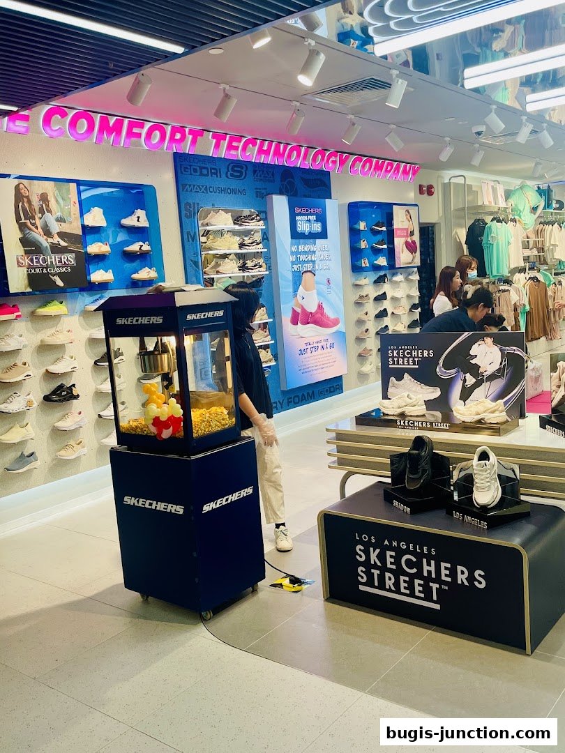 Interior of a Skechers store showcasing shoes, apparel, and a popcorn machine.