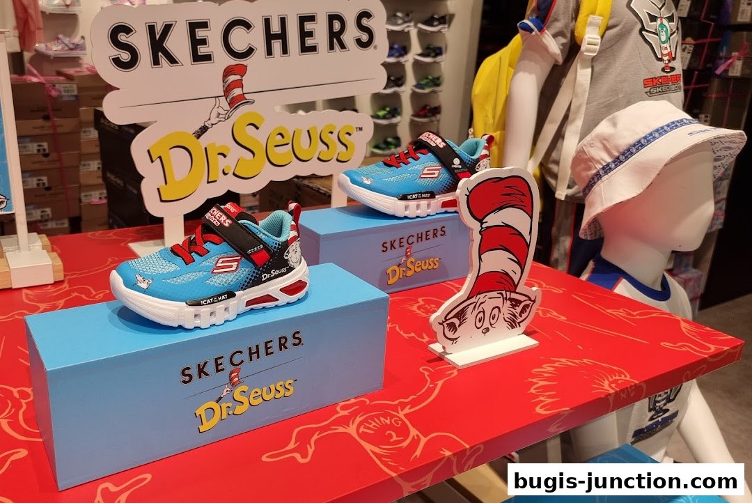 Skechers Dr. Seuss collaboration shoes displayed on blue boxes with a mannequin wearing a bucket hat.