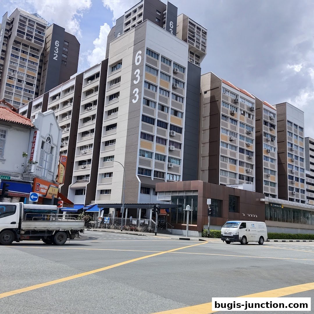 A street view of modern apartment buildings with shops on the ground floor.