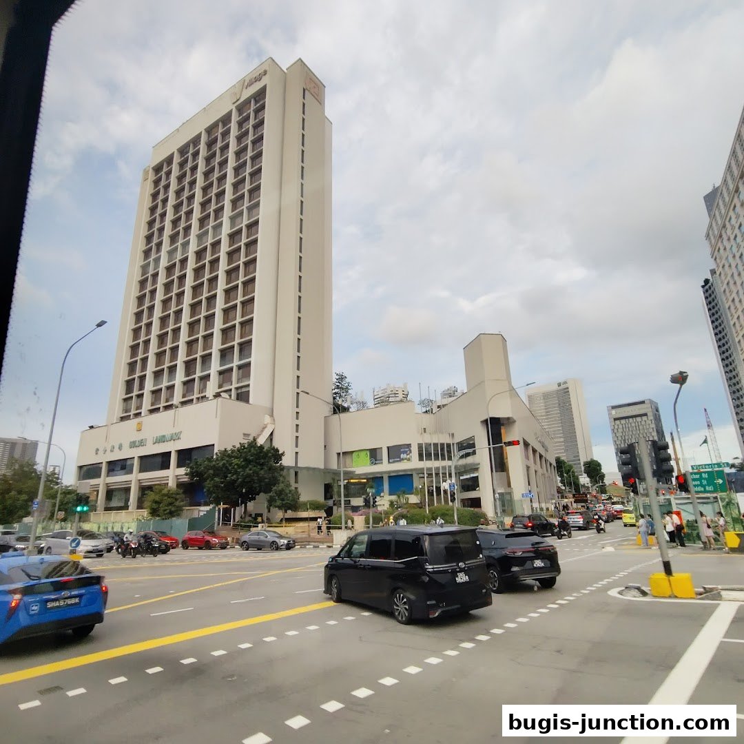 A street view of the Golden Landmark building with traffic and pedestrians.