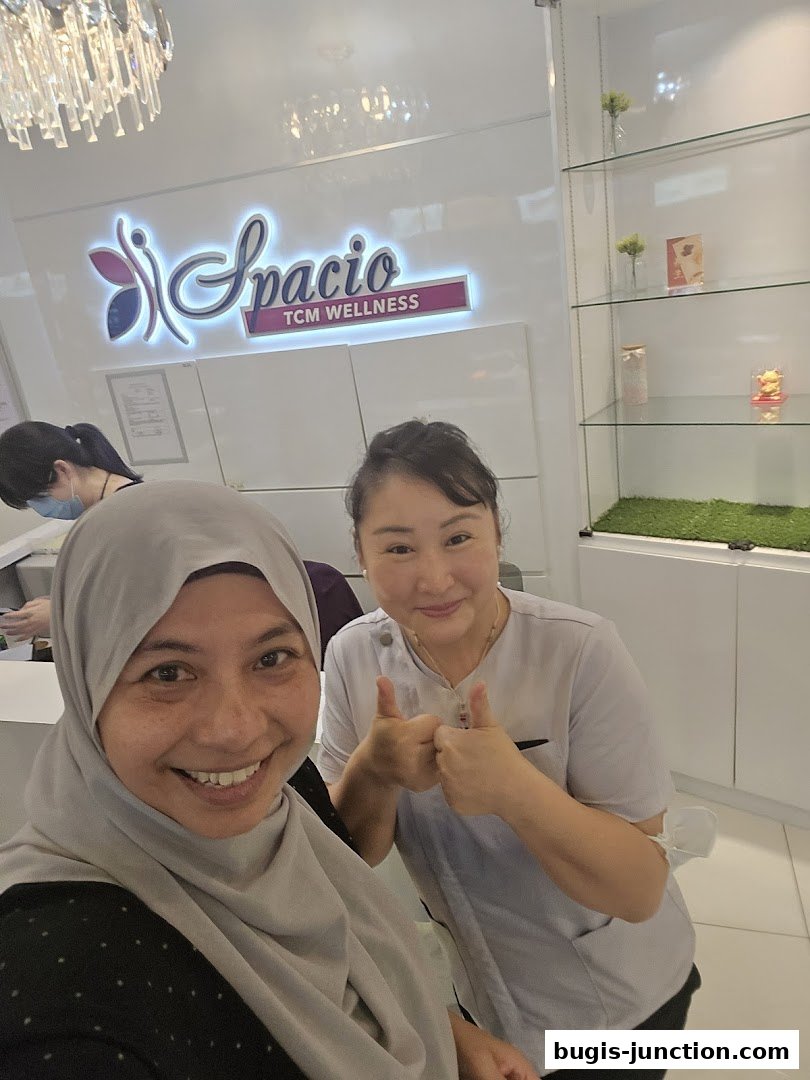 Two women smiling and giving thumbs up in a clean, modern wellness center.