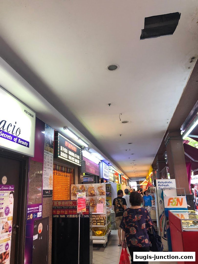 A view of a shopping mall corridor with several shops, including Spacio TCM Wellness.