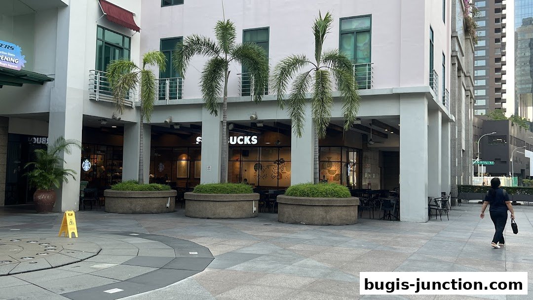 Starbucks Bugis Junction shop front with outdoor seating and palm trees.