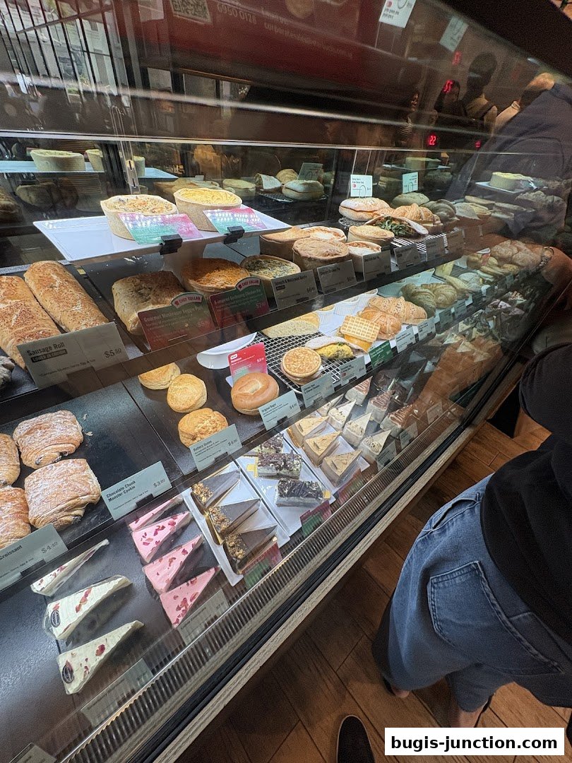 A display case filled with various pastries, cakes, and savory items at Starbucks.