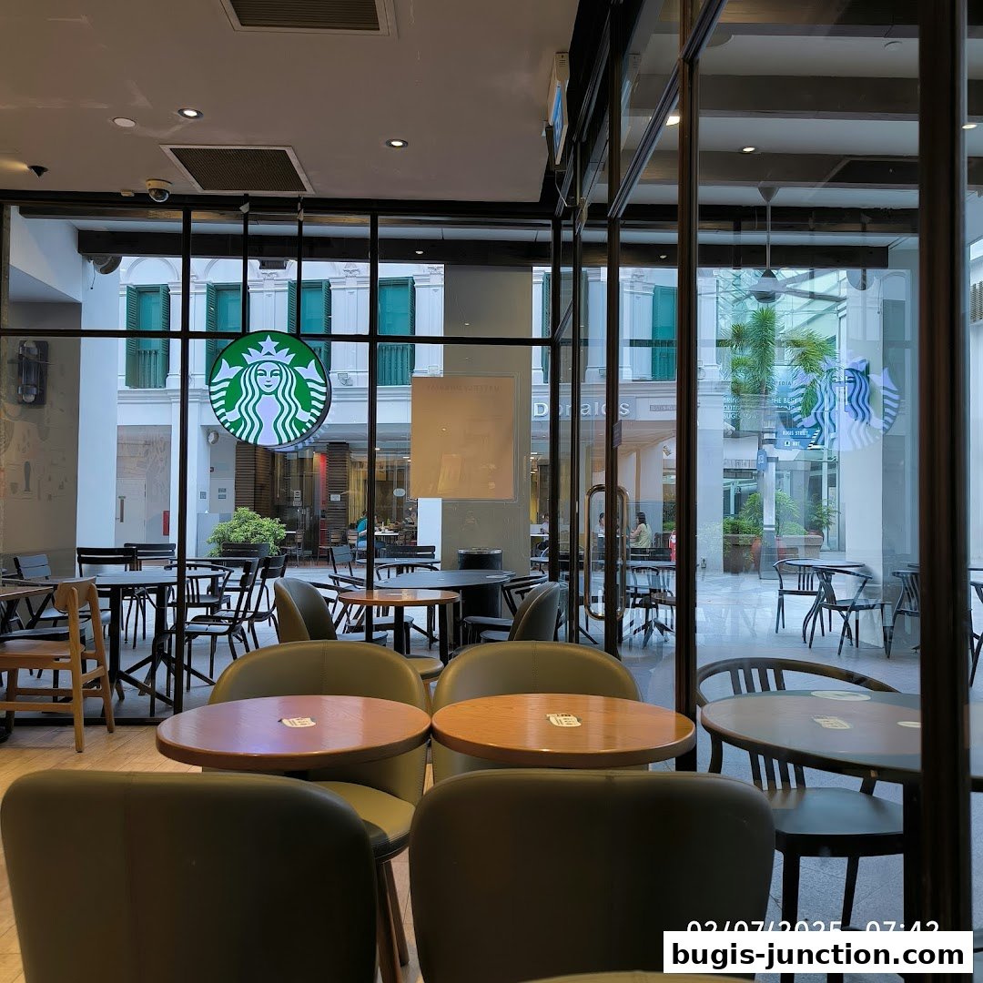 Interior view of a Starbucks cafe with tables, chairs, and the iconic logo visible.