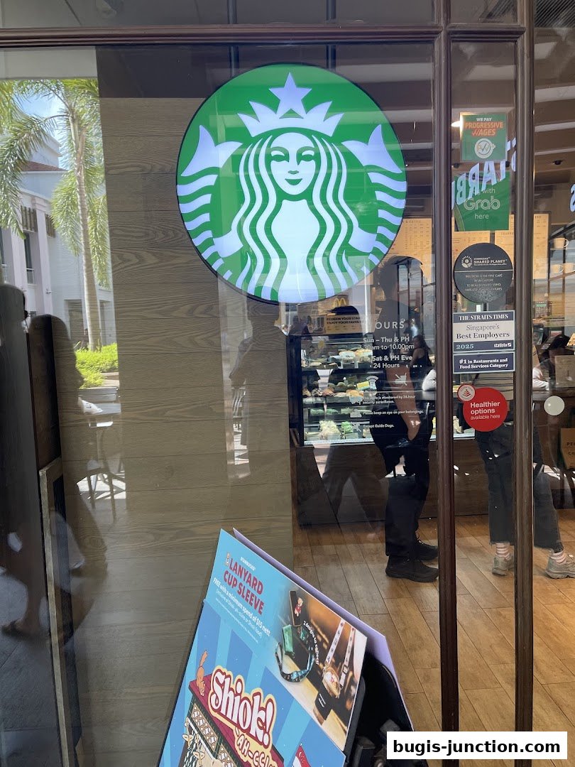 The entrance of a Starbucks store with the iconic logo and promotional materials displayed.