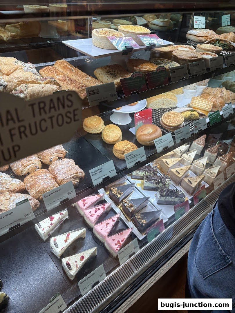 A display case filled with various pastries, cakes, and baked goods at Starbucks.