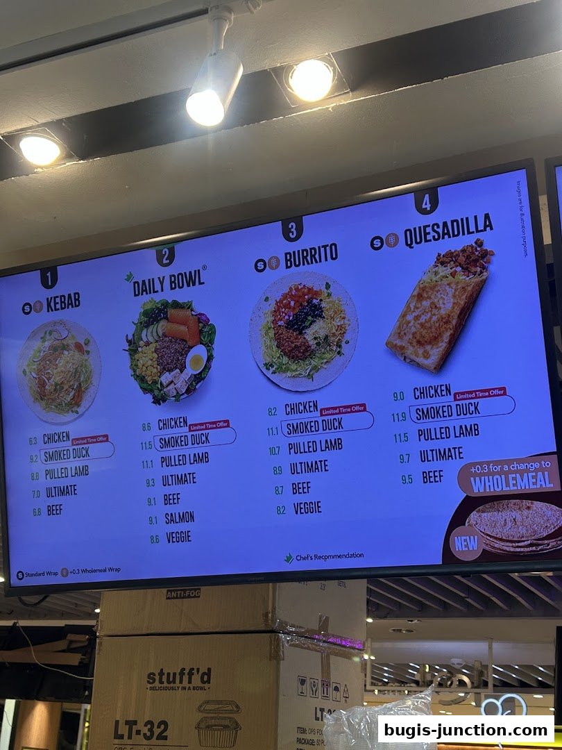 A digital menu board displaying four main meal options: Kebab, Daily Bowl, Burrito, and Quesadilla with various protein choices.