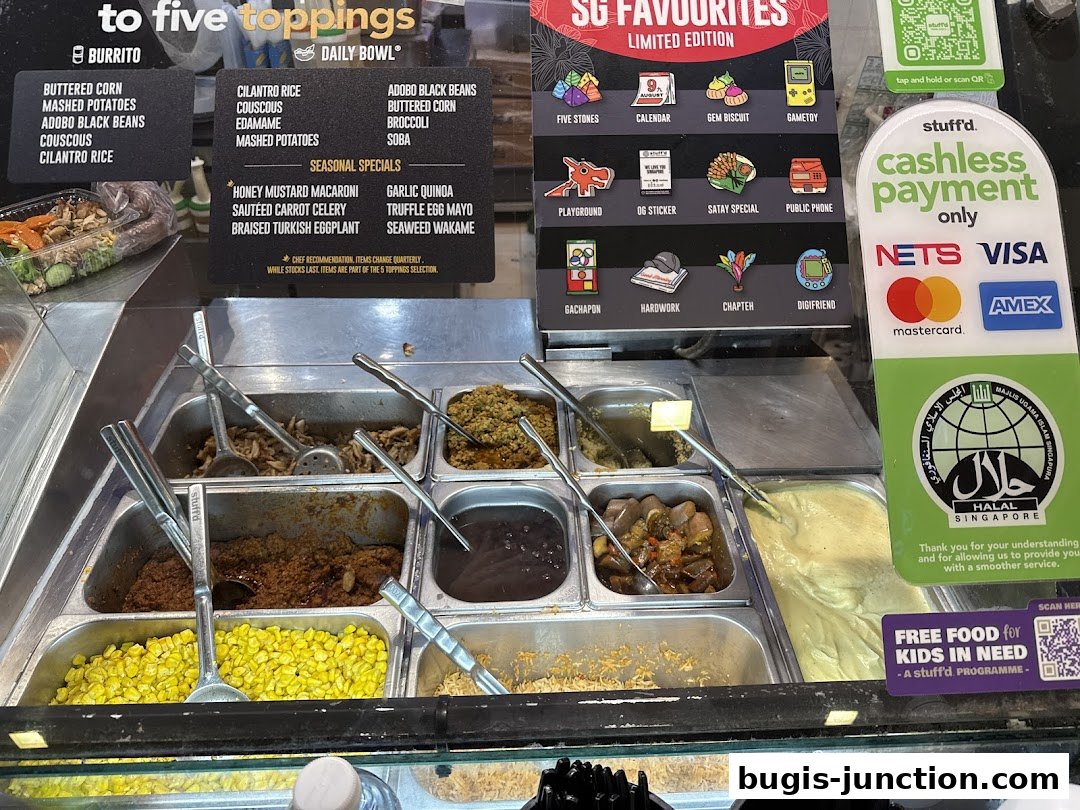 A display of various food toppings and payment options at a Stuff'd restaurant.
