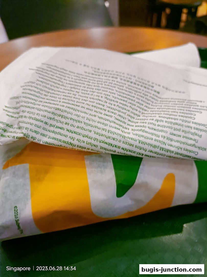 A close-up view of Subway branded wrappers with text detailing ingredients and allergens.