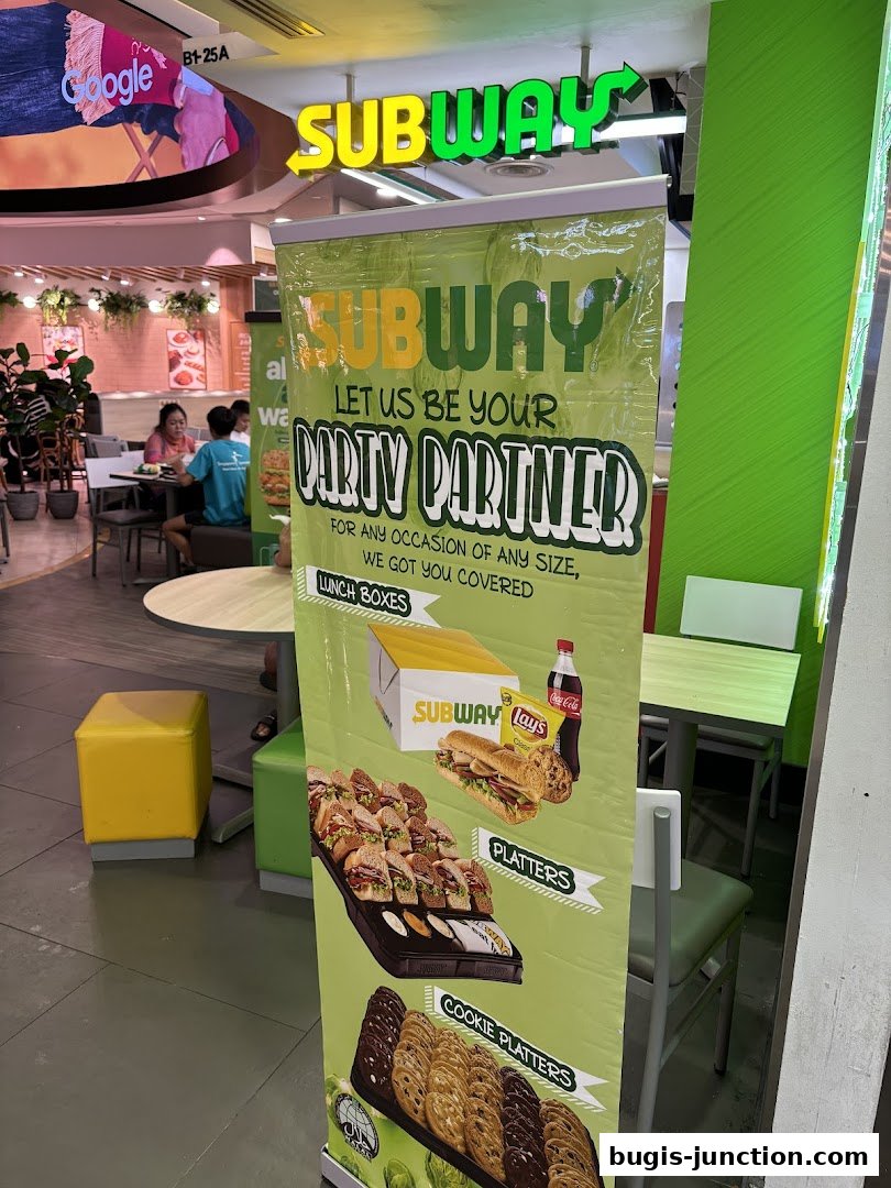 A Subway shop with a promotional banner for party platters and lunch boxes.
