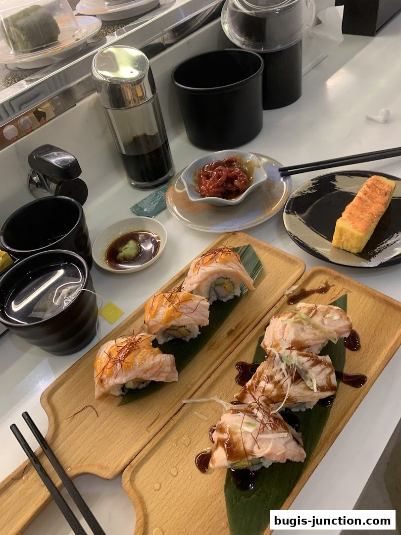 Delicious sushi rolls and tamagoyaki served on wooden platters with dipping sauce.