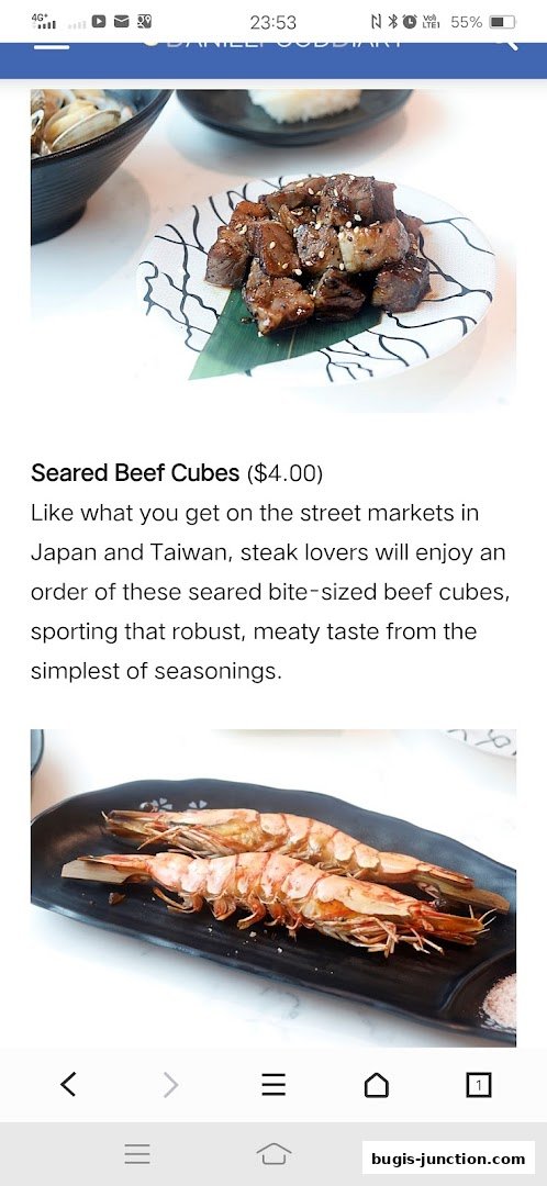 A close-up of seared beef cubes and grilled prawns, with text describing the beef.