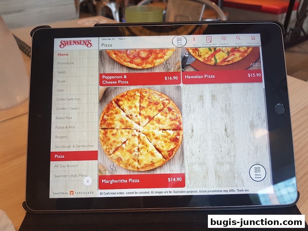 A tablet displays the Swensen's pizza menu with various pizza options and prices.