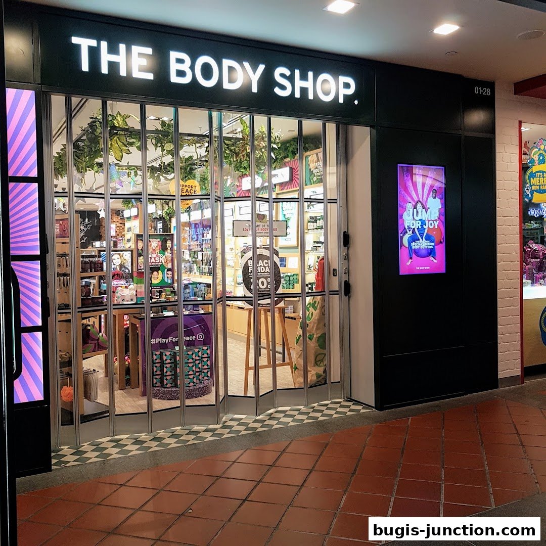 The Body Shop storefront with its signature green branding and a display of products inside.