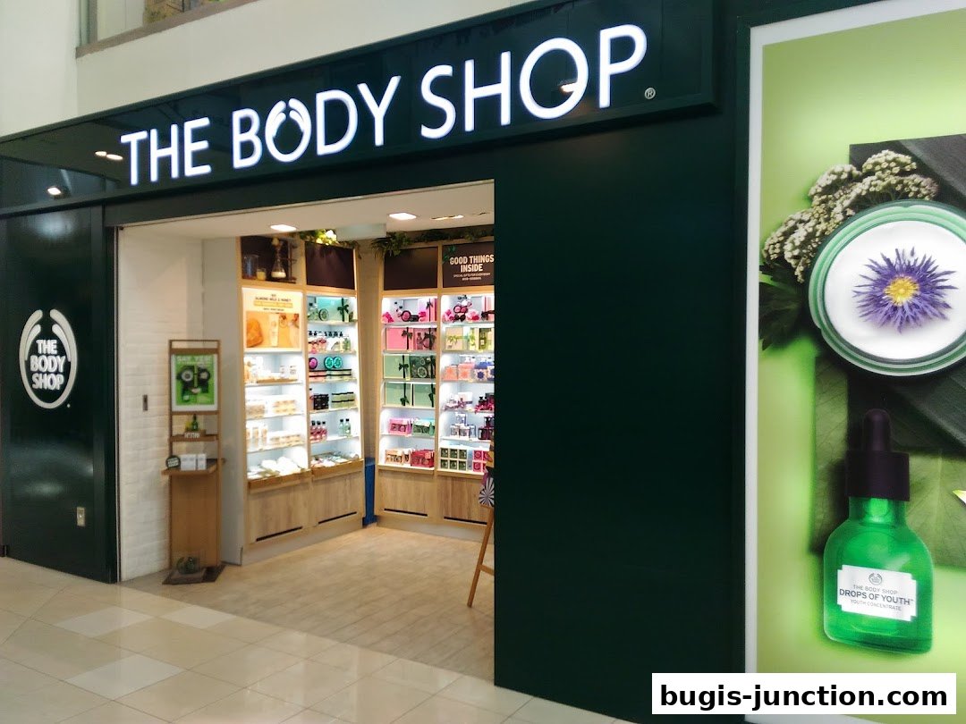 The Body Shop storefront with illuminated signage and displays of beauty products inside.