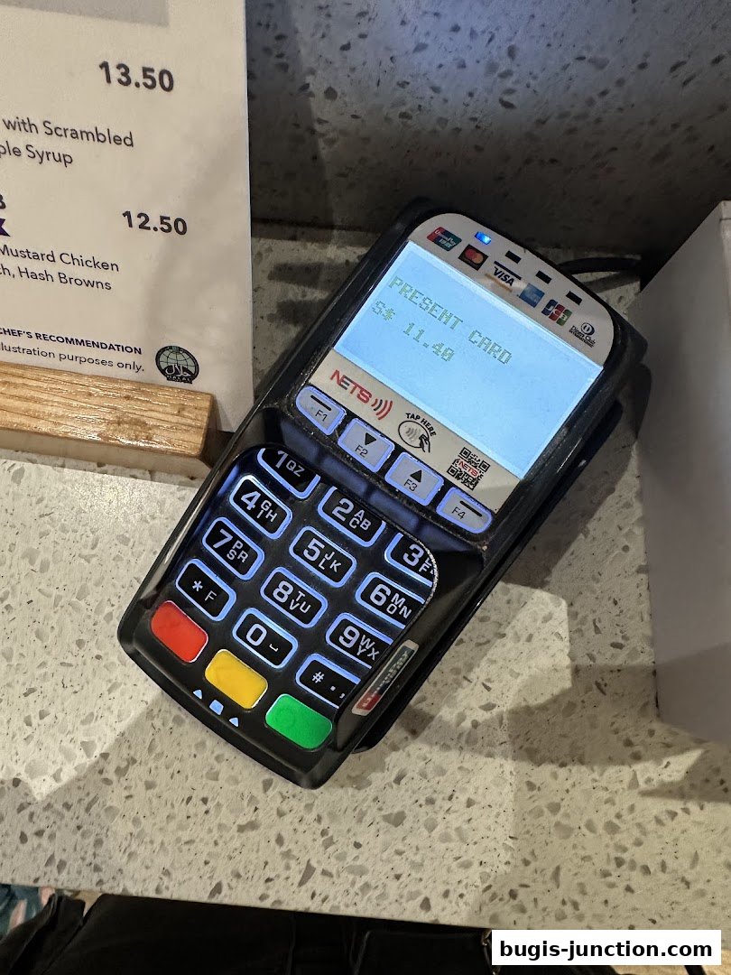 A payment terminal displaying a transaction amount next to a menu with food items.