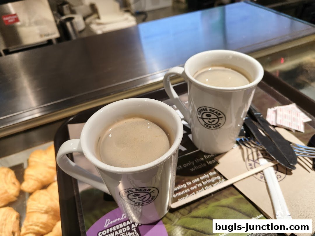 Two mugs of coffee and croissants on a tray at The Coffee Bean and Tea Leaf.