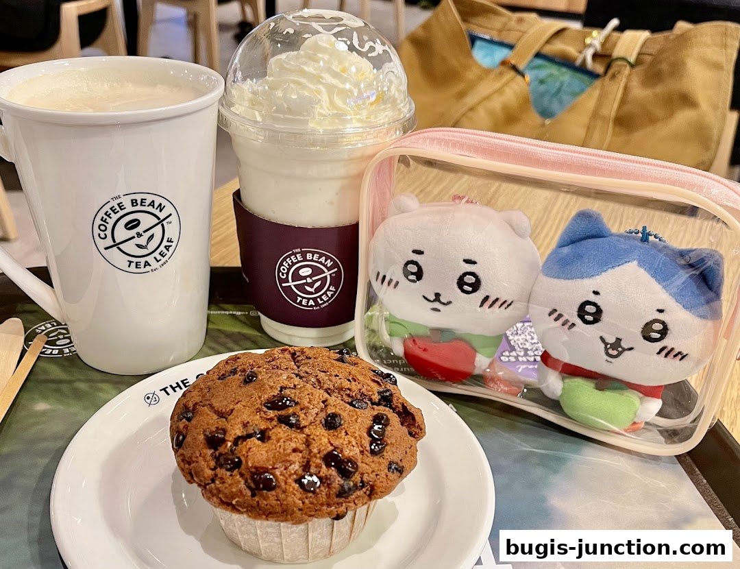 A chocolate chip muffin, a coffee, and a blended drink with whipped cream.