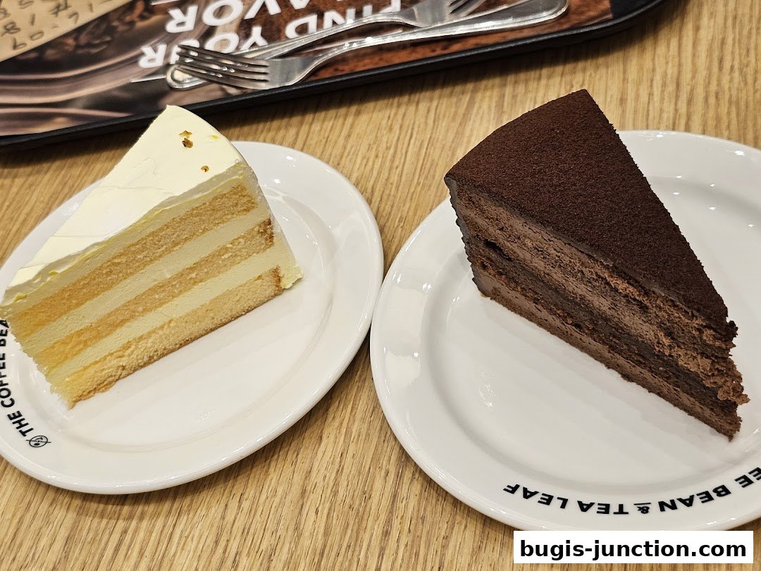 Two slices of cake, one vanilla and one chocolate, served on white plates.