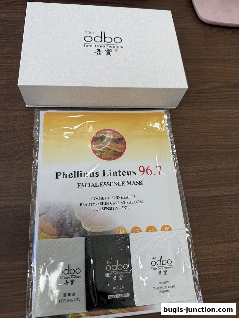 A white gift box with a facial essence mask and three small sample packets from The odbo.