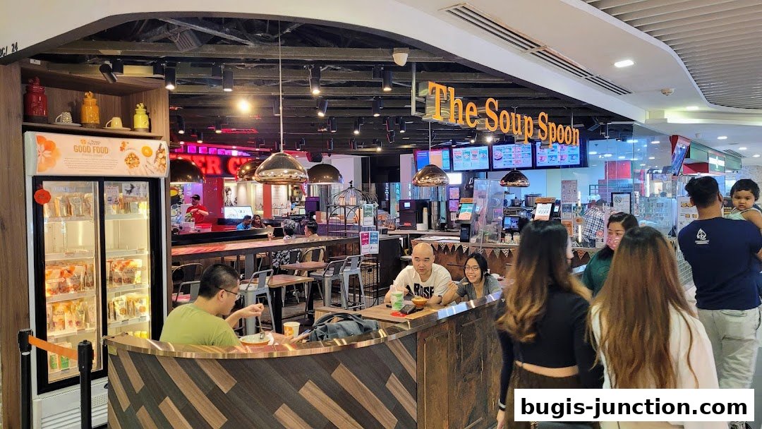Customers dine at The Soup Spoon, a casual eatery with a modern interior and display fridge.