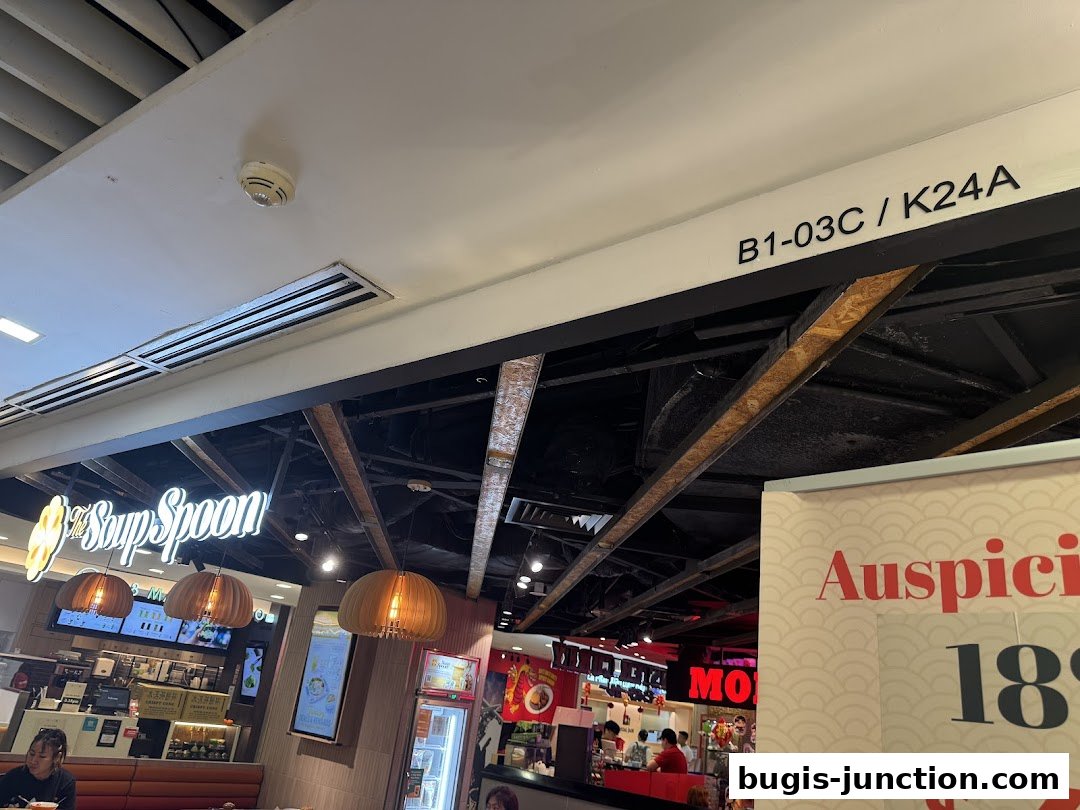 Interior view of The Soup Spoon restaurant with its illuminated sign and hanging lamps.