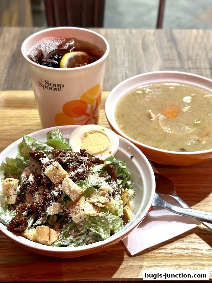 A delicious meal featuring a salad, soup, and a drink from The Soup Spoon.