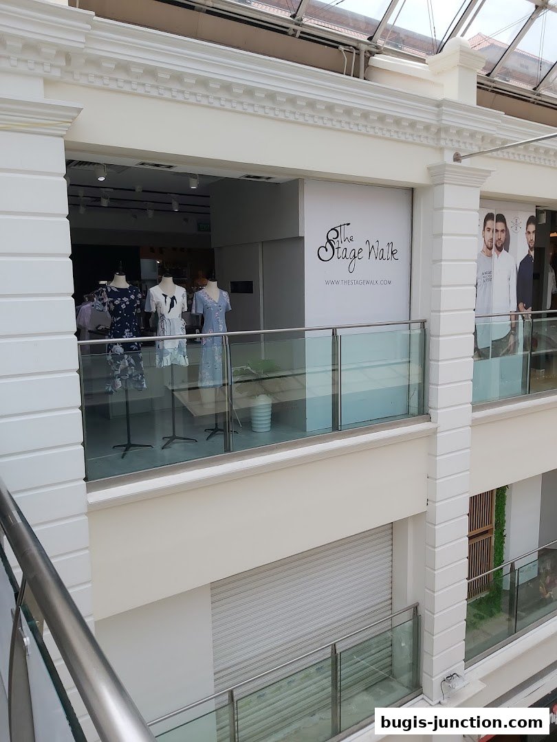 The Stage Walk shop front with mannequins displaying dresses and the shop's logo.