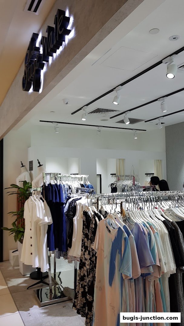 The Stage Walk clothing store interior with racks of stylish women's apparel.