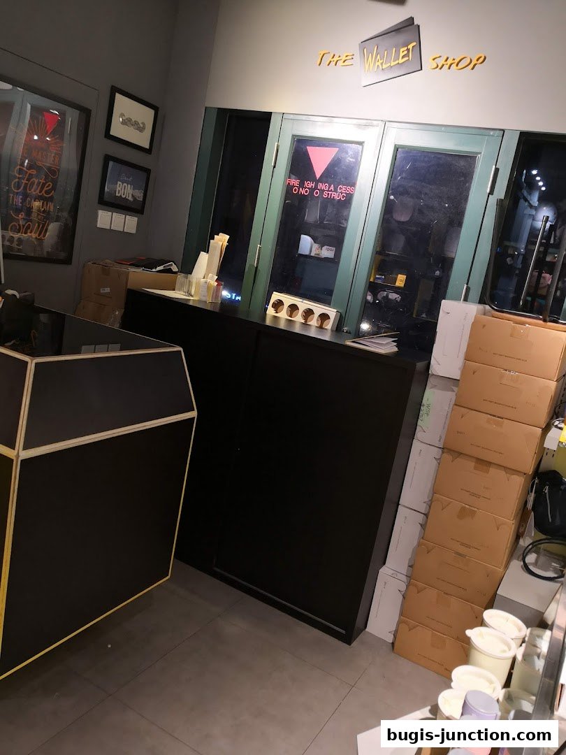 Interior view of The Wallet Shop with a counter, boxes, and framed art on the wall.
