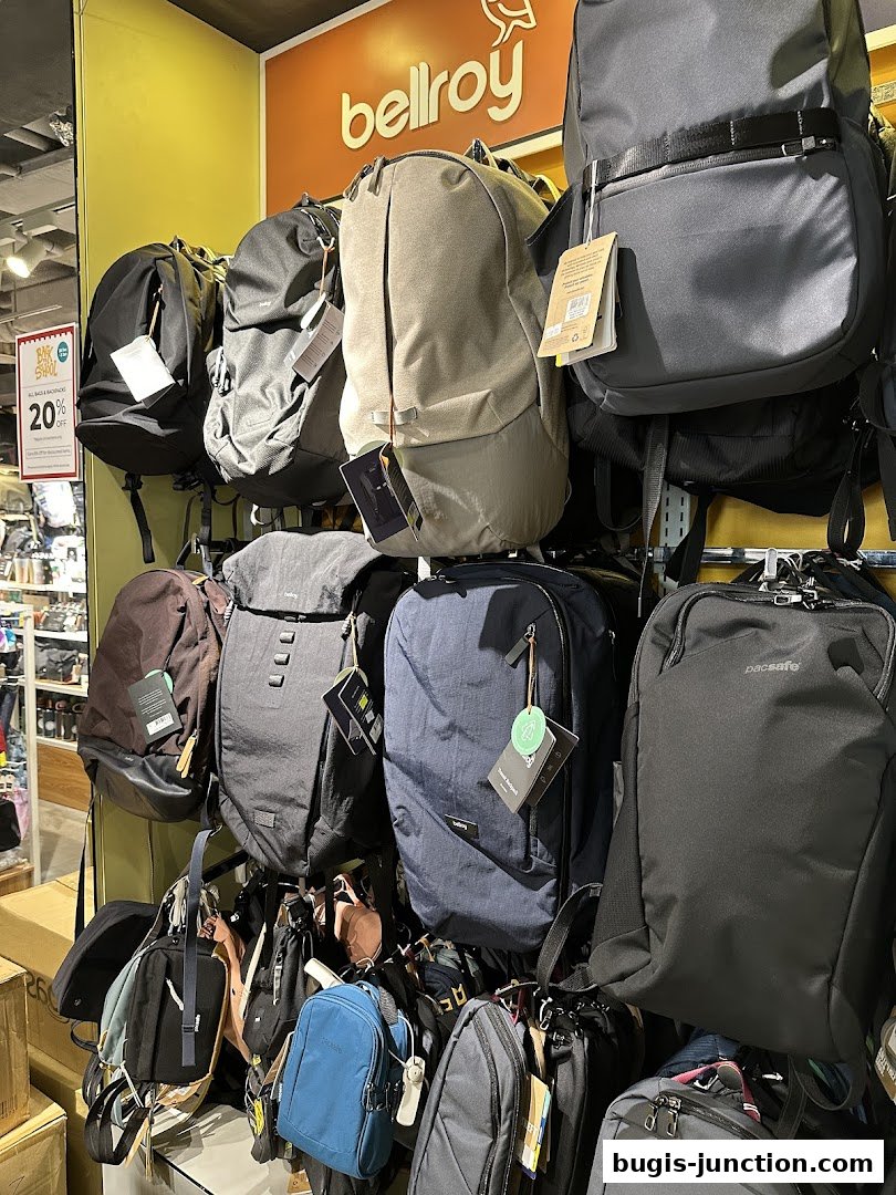 A wall display of various backpacks and bags from brands like Bellroy and Pacsafe.