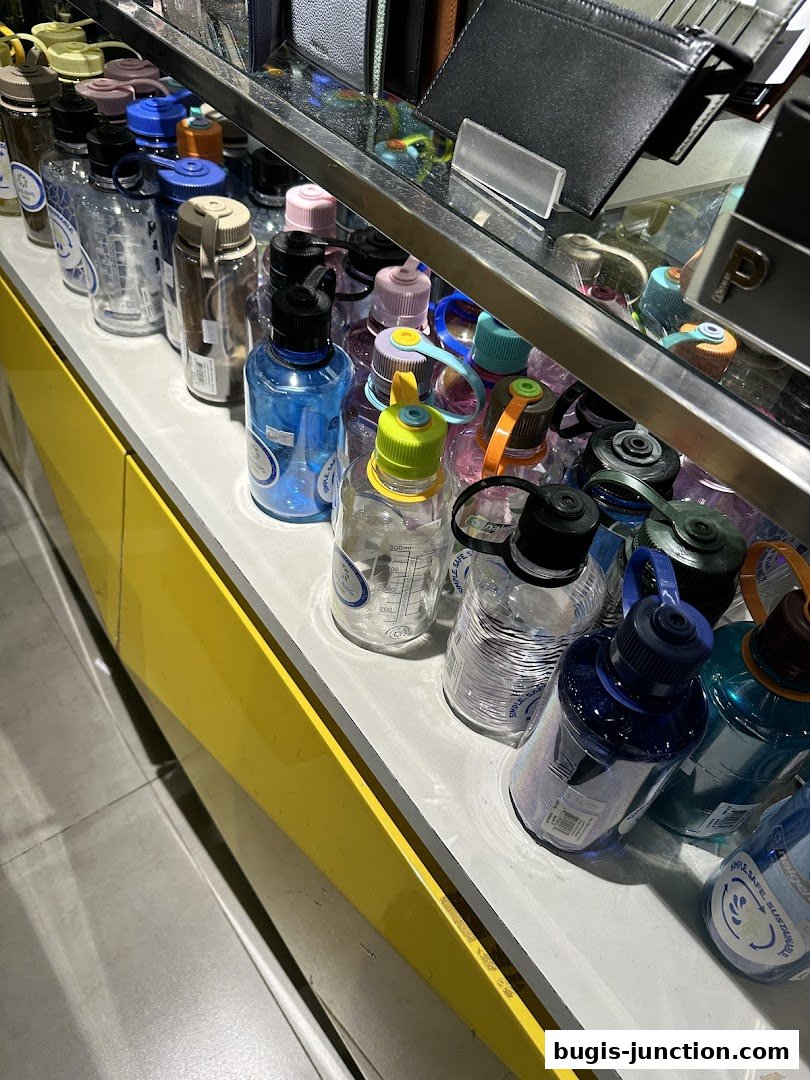 A display of colorful water bottles and wallets on shelves in a retail store.
