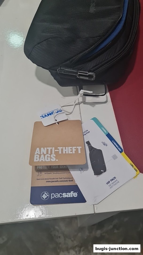A black Pacsafe anti-theft hip pack with product tags attached.