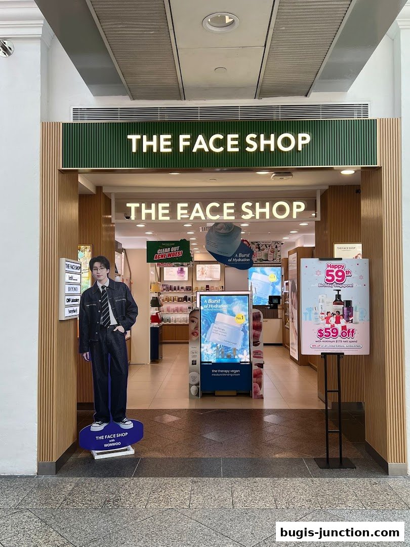 The entrance of THE FACE SHOP, featuring a cutout of a celebrity and promotional posters.
