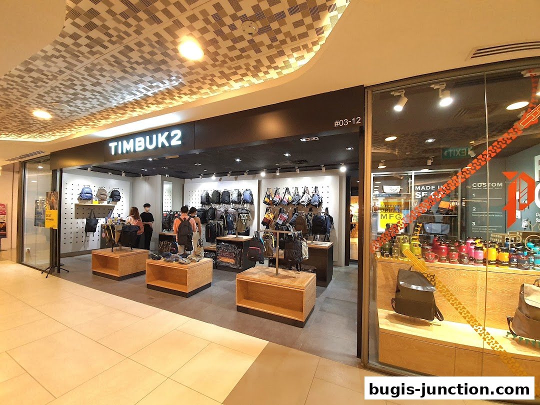 The Timbuk2 shop displays a wide selection of backpacks and bags, with customers browsing inside.
