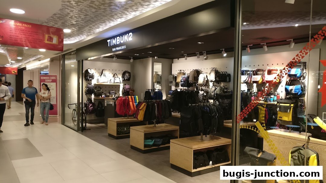 The Timbuk2 store displays a wide variety of backpacks and bags in a modern retail setting.