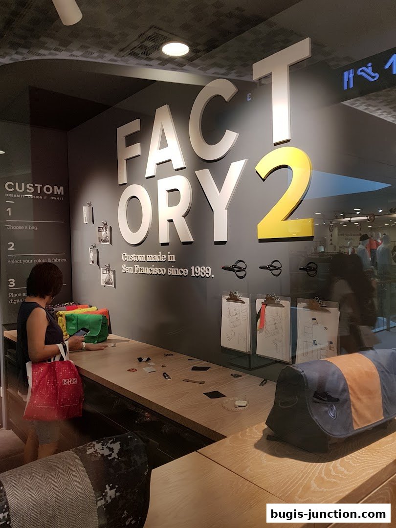 A customer interacts with a custom bag design display at Timbuk2.